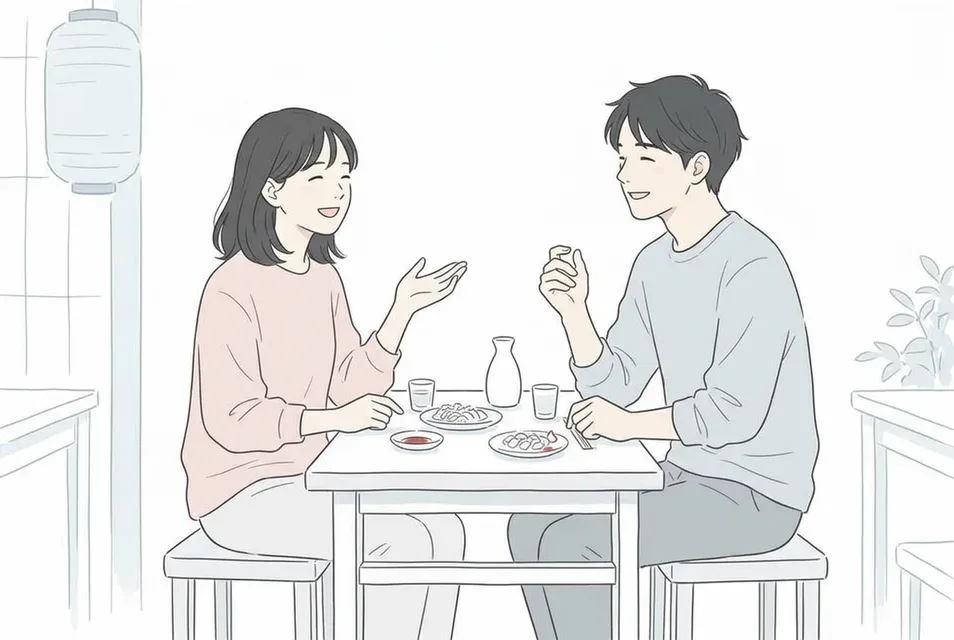 相席居酒屋のテーブル席で共通の話題を見つけて笑顔で楽しそうに話す男女