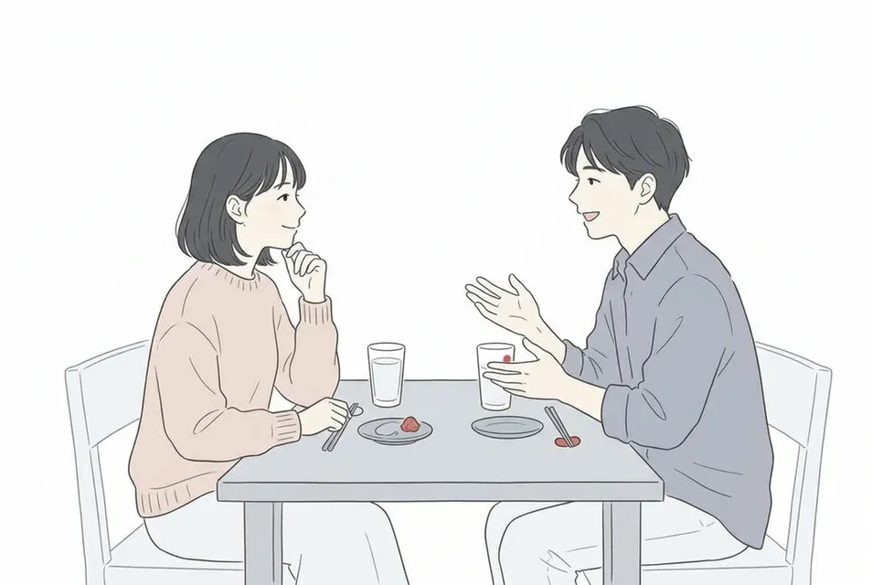 居酒屋のテーブルで男性の話に笑顔で耳を傾け相づちを打つ女性