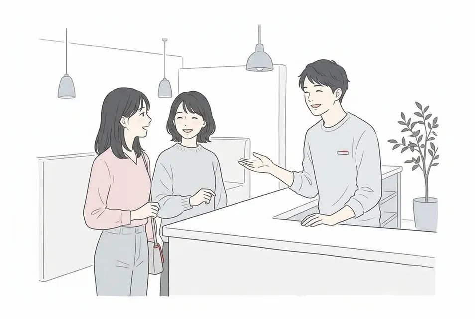 相席居酒屋の受付カウンターで店員と話す女性2人組の来店客